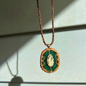 Green, tan/brown pendant with a black and white stone